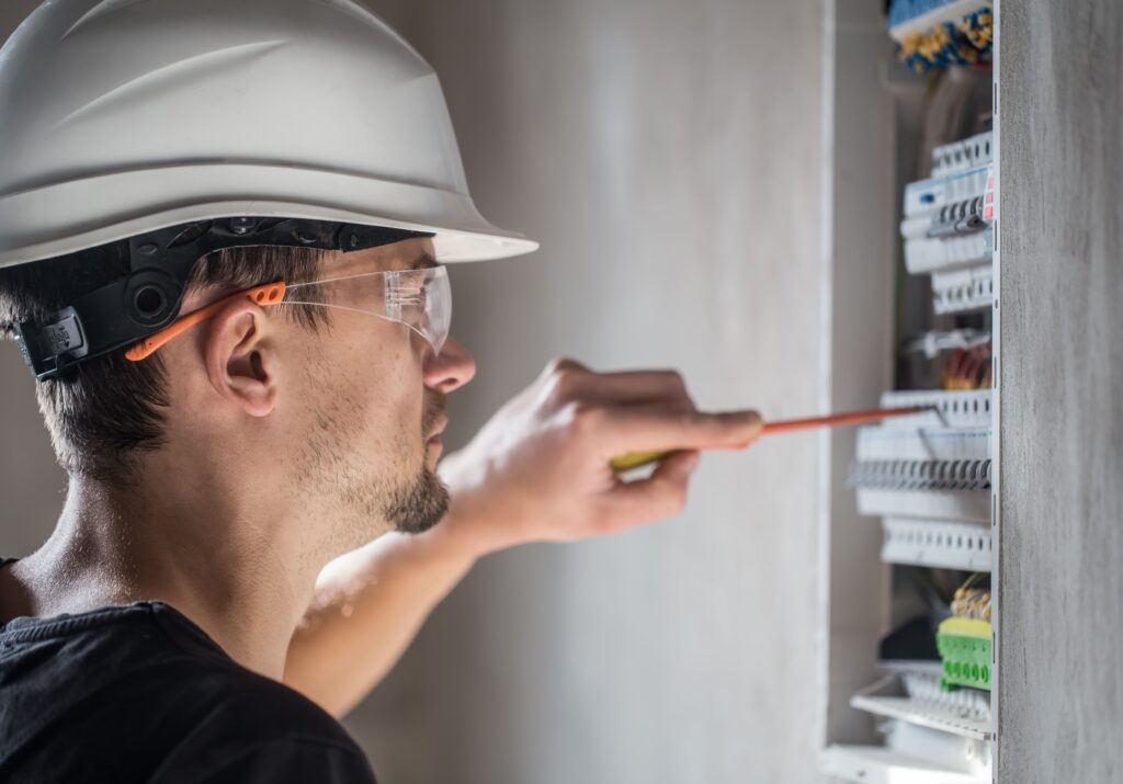 man-electrical-technician-working-switchboard-with-fuses-installation-connection-electrical-equipment-close-up-min